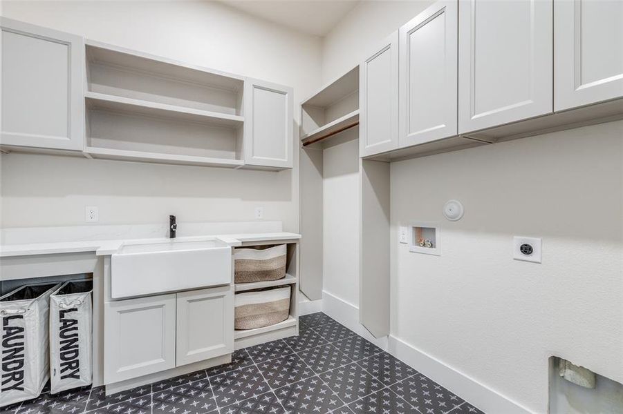 Laundry area featuring hookup for an electric dryer, sink, cabinets, tile patterned flooring, and washer hookup