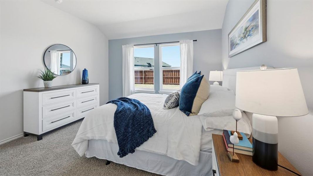 This room features a window with white curtains, light-colored carpeting, and walls painted in two different tones