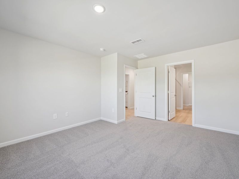 Relax in the spacious primary suite featuring an ensuite bath with dual sinks and a walk-in closet.