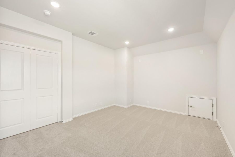 Empty bedroom with white walls, gray carpet, double closet doors, and recessed lighting Empty bedroom with white walls, gray carpet, double closet doors, and recessed lighting