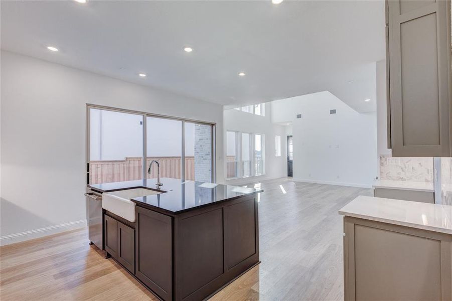 Kitchen featuring an island with sink, light hardwood / wood-style floors, sink, and dishwasher