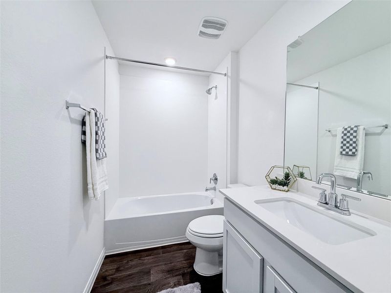 Bathroom with vanity, dark wood-style floors, and tub / shower combination Bathroom with vanity, dark wood-style floors, and tub / shower combination