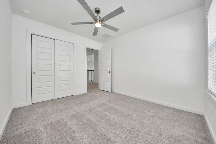 Generously sized secondary bedrooms featuring spacious closets, soft and inviting carpeting underfoot, large windows allowing plenty of natural light, and the added touch of privacy blinds for your personal retreat. Sample photo of completed home with similar floor plan. Actual colors and selections may vary.