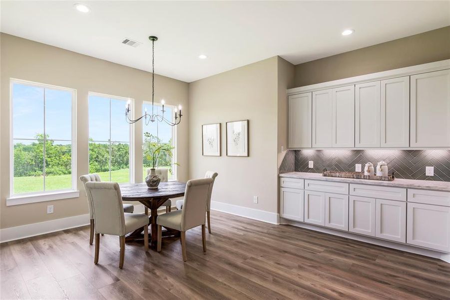 This bright dining area features large, a stylish chandelier, and elegant wood flooring. The built-in cabinetry offers ample storage This bright dining area features large, a stylish chandelier, and elegant wood flooring. The built-in cabinetry offers ample storage