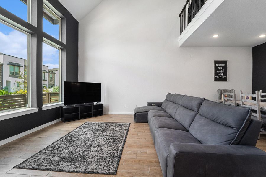 Soaring two-story windows bring in natural light with modern accent wall detail.