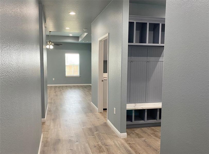 A well-lit entryway boasts durable laminate flooring and a custom built-in storage unit, leading to a spacious living area. A well-lit entryway boasts durable laminate flooring and a custom built-in storage unit, leading to a spacious living area.