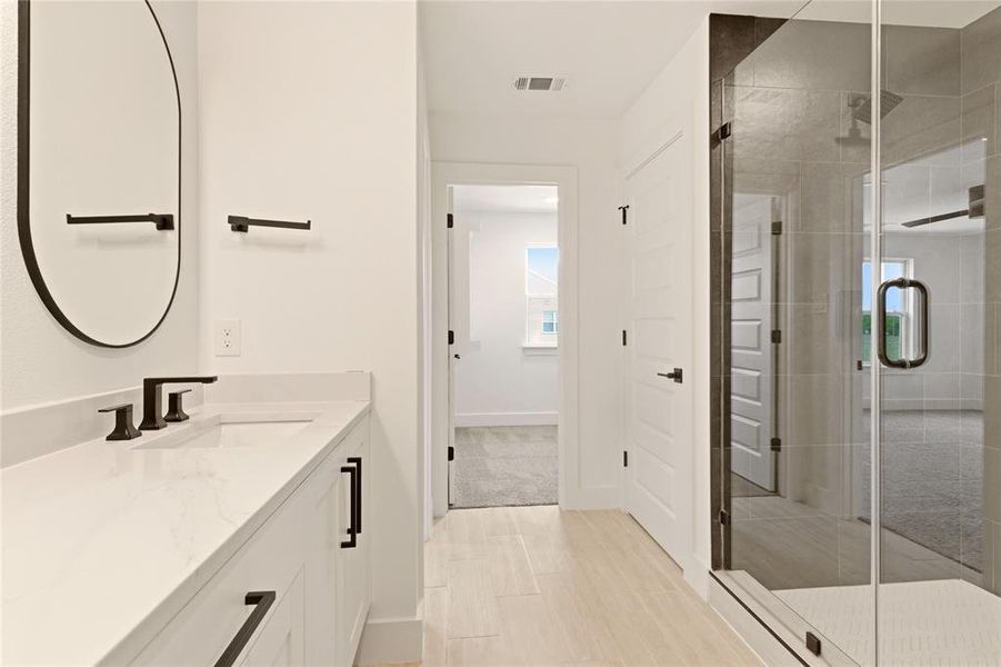 Full bathroom featuring vanity, a shower stall, and wood finish floors