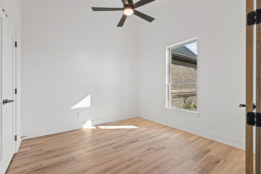 Unfurnished bedroom featuring wood tiled floors and a ceiling fan