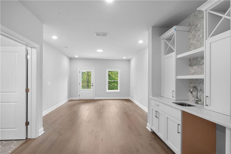Bar area featuring open shelves, dark wood finished floors, white cabinets, light stone counters, and recessed lighting Bar area featuring open shelves, dark wood finished floors, white cabinets, light stone counters, and recessed lighting
