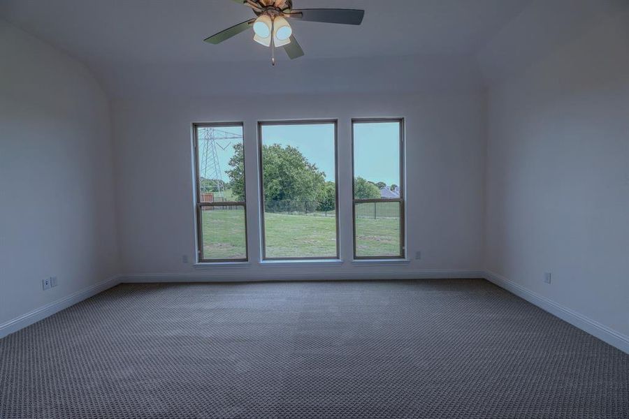 Unfurnished room with carpet floors, baseboards, and ceiling fan