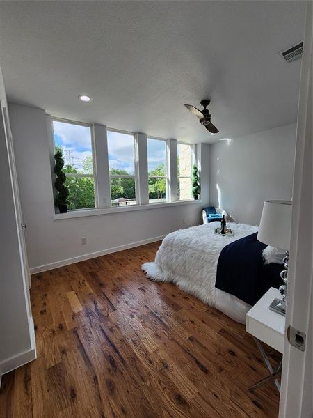 Bedroom featuring dark hardwood / wood-style floors, a textured ceiling, and ceiling fan