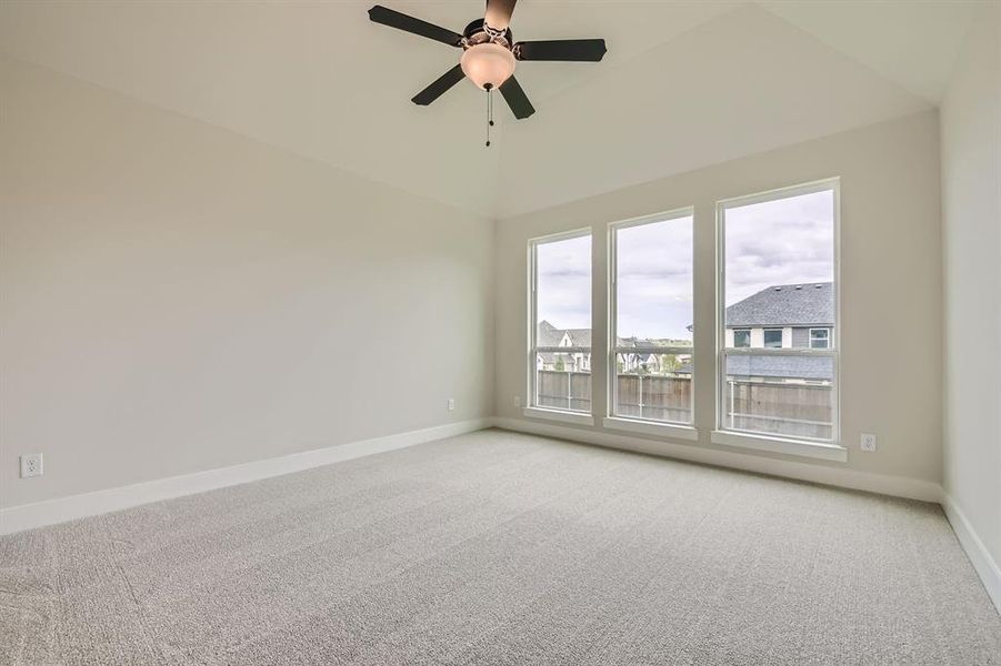 Empty room with light carpet, ceiling fan, and lofted ceiling