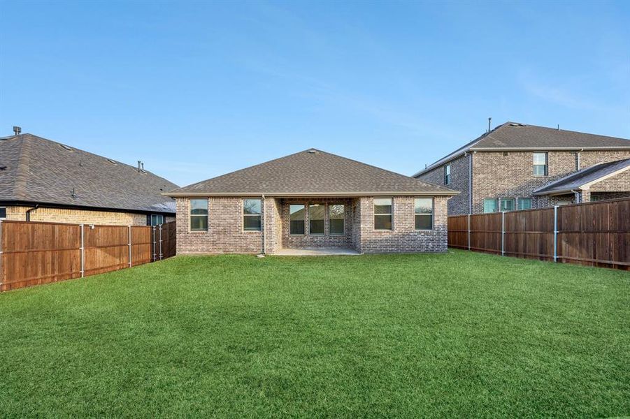 Rear view of house with a patio area and a lawn