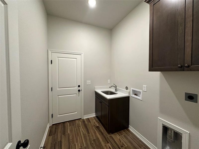 Laundry room with cabinet space, wood finish floors, hookup for a washing machine, and electric dryer hookup Laundry room with cabinet space, wood finish floors, hookup for a washing machine, and electric dryer hookup