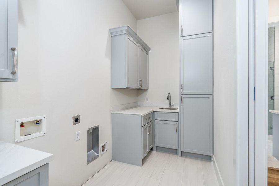 Laundry room includes washer and dryer connections, plenty of cabinet space, and a sink for convenience. Laundry room includes washer and dryer connections, plenty of cabinet space, and a sink for convenience.