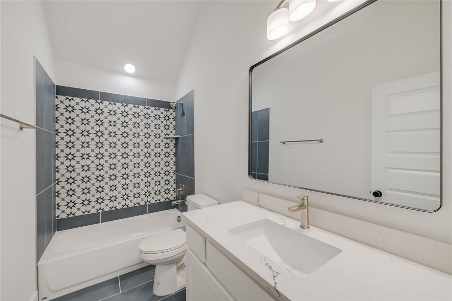 Full bath with tile patterned flooring, bathing tub / shower combination, vanity, and toilet