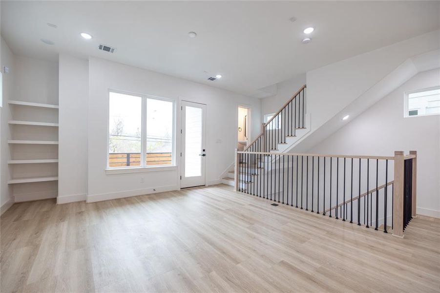 Alternate view of the second-floor living area highlights access to your private balcony. Built-in shelving on the right adds a stylish touch while maximizing storage space.