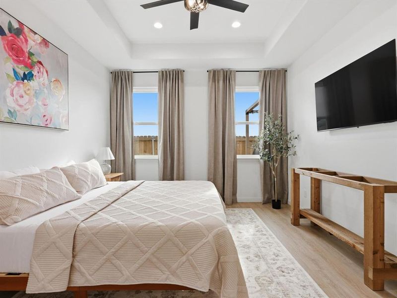 Primary bedroom is a relaxing oasis with large windows and coffered ceilings.