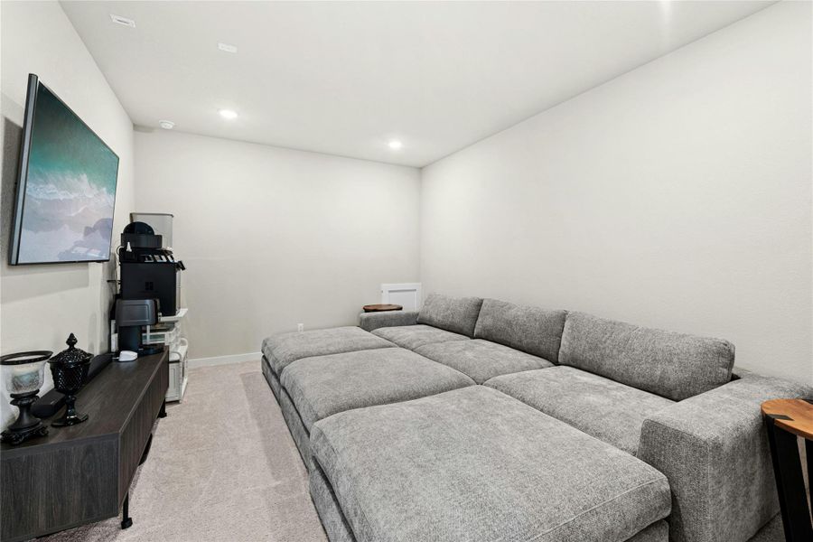Media room featuring light colored carpet and recessed lighting