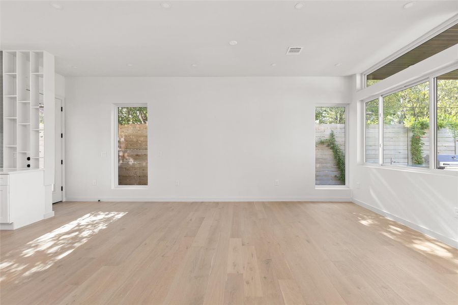 Spare room featuring healthy amount of natural light, light wood-type flooring, and recessed lighting