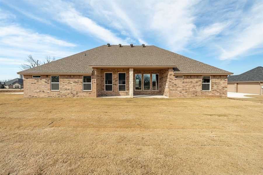 Rear view of house featuring a patio area and a yard