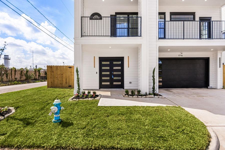 A stylish covered front patio sets the stage for a warm welcome, while the mordern black double doors, and professionally landscaped grounds creates a bold elegant entrance.