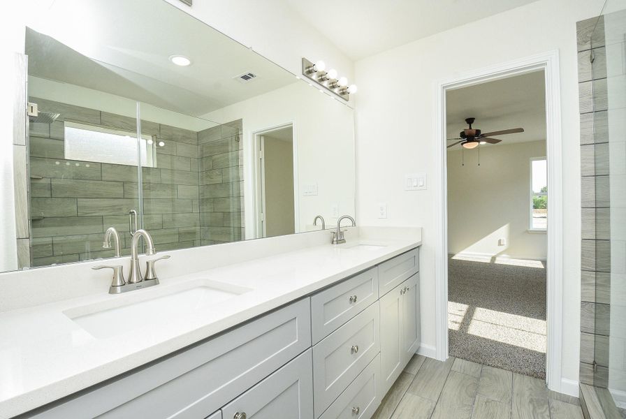 This is a modern bathroom with dual vanities, large mirrors, and a spacious walk-in shower. The room is well-lit with a combination of natural and artificial light. This is a modern bathroom with dual vanities, large mirrors, and a spacious walk-in shower. The room is well-lit with a combination of natural and artificial light.