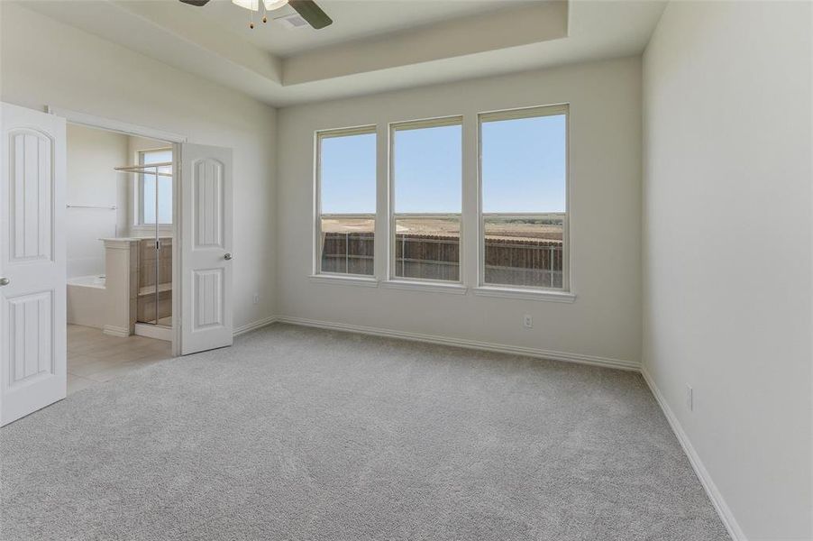 Spacious room featuring light-colored carpeting and white walls Spacious room featuring light-colored carpeting and white walls