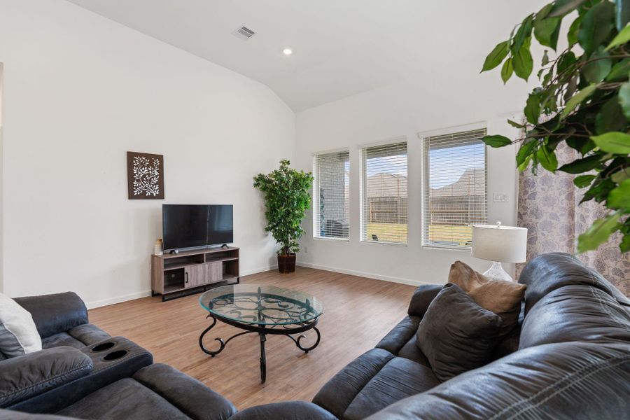 Living area features high ceilings, recessed lighting, and a wall of windows looking out to the large backyard!