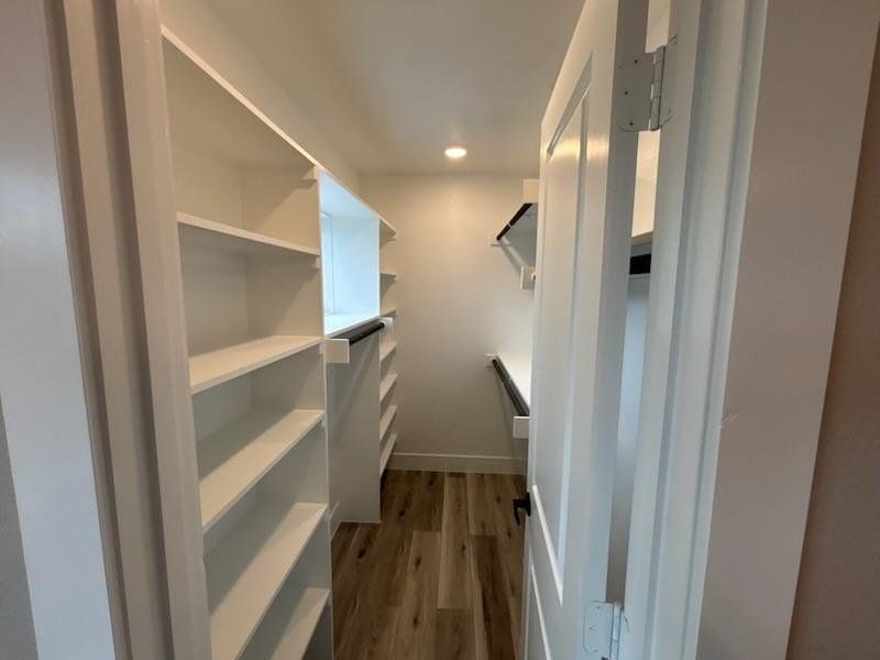 Spacious closet with dark wood finished floors Spacious closet with dark wood finished floors