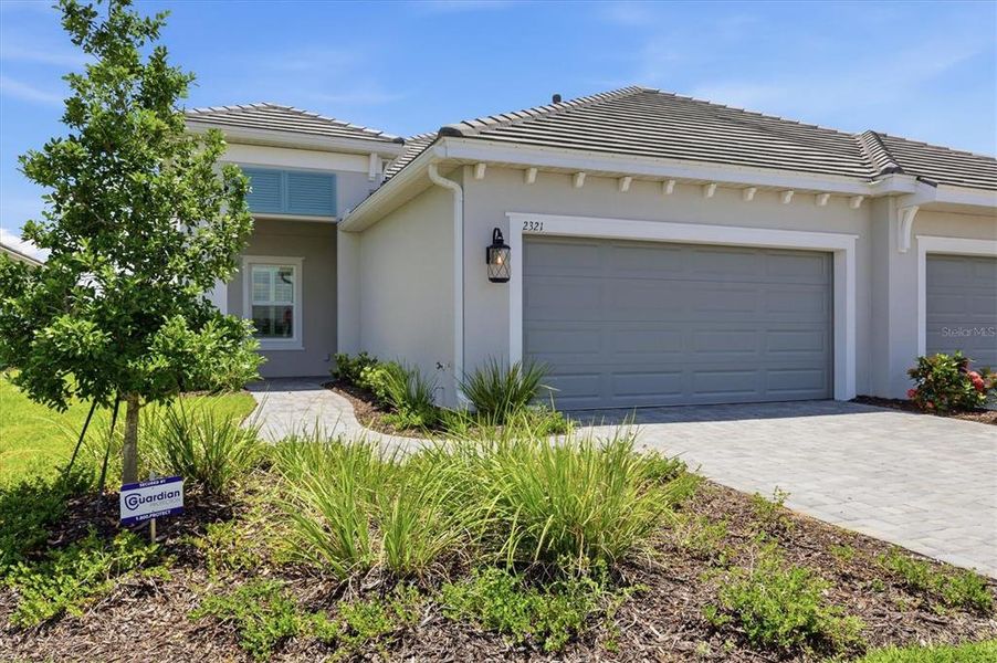 Front exterior of a new home in Windward, Lakewood Ranch, FL, highlighting curb appeal (Image 2). Front exterior of a new home in Windward, Lakewood Ranch, FL, highlighting curb appeal (Image 2).