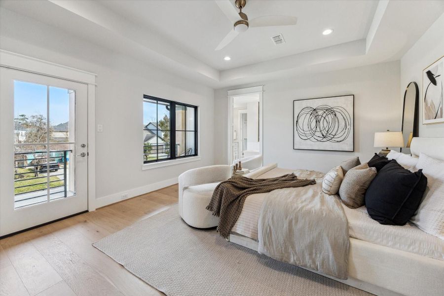 Spacious primary bedroom offers a balcony off the front of the home.
