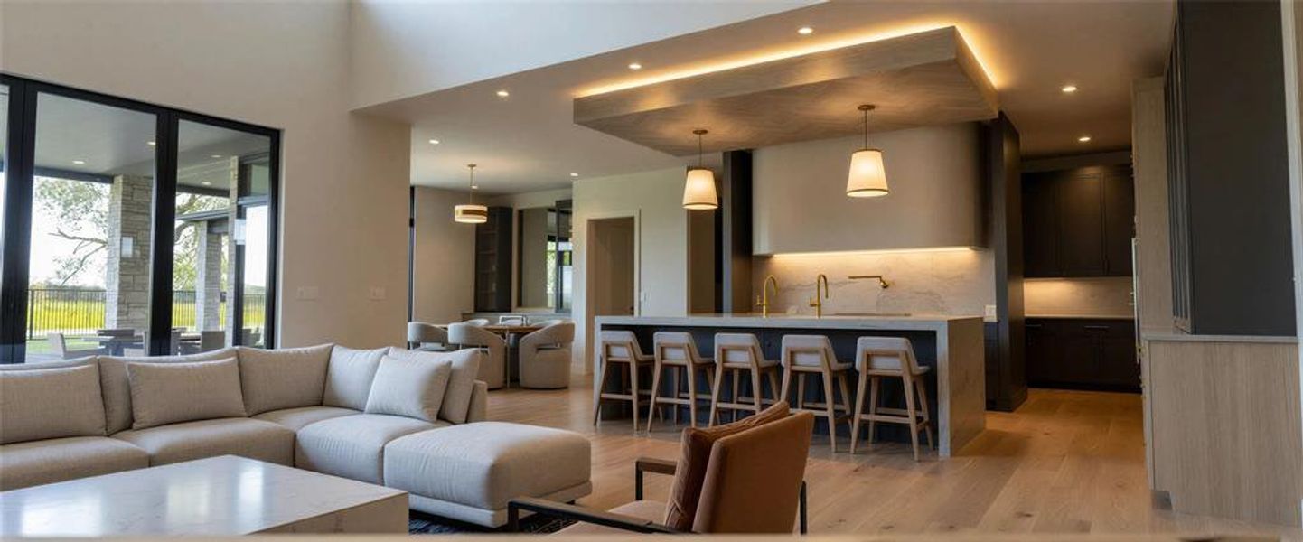 Kitchen featuring tasteful backsplash, dark wood finished floors, stainless steel appliances, light stone counters, and hanging light fixtures