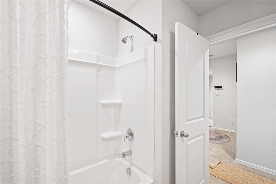 Full bathroom featuring shower / tub combo and light tile patterned floors