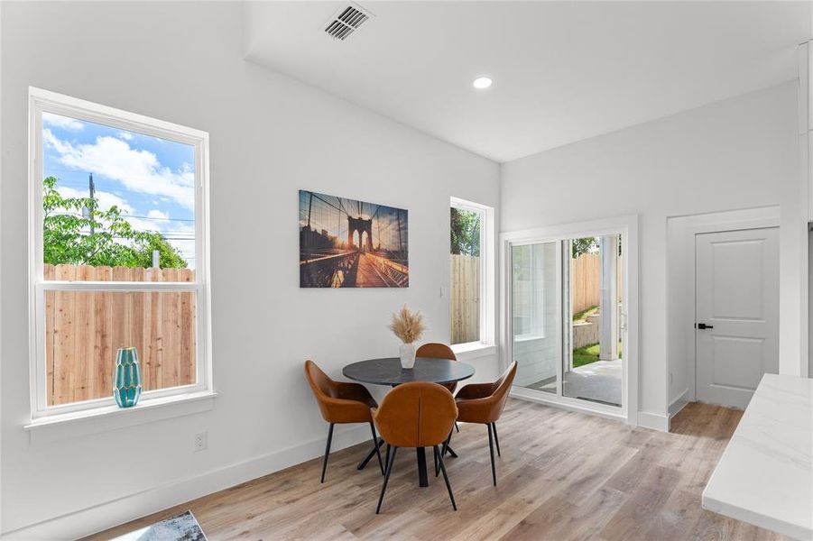 Dining area featuring wood-finish flooring, recessed lighting, and a sliding glass door to the outdoor space