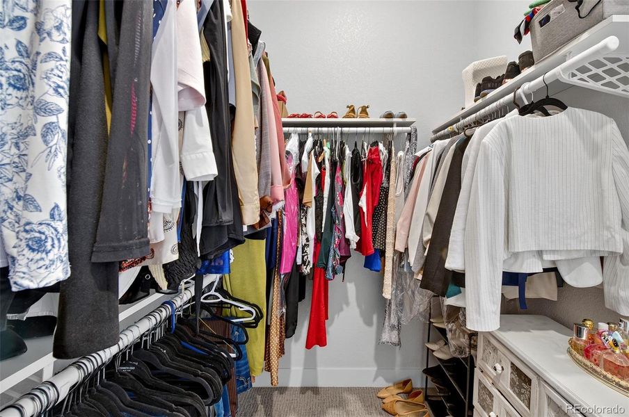 Primary Closet – Generous walk-in closet with built-in hanging storage and shelving, providing convenient organization and access from the primary suite.