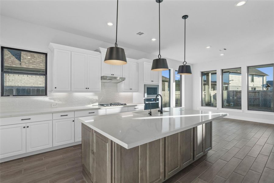 Pristine and functional, the central kitchen island provides both a focal point and practical prep space in this modern gourmet kitchen.