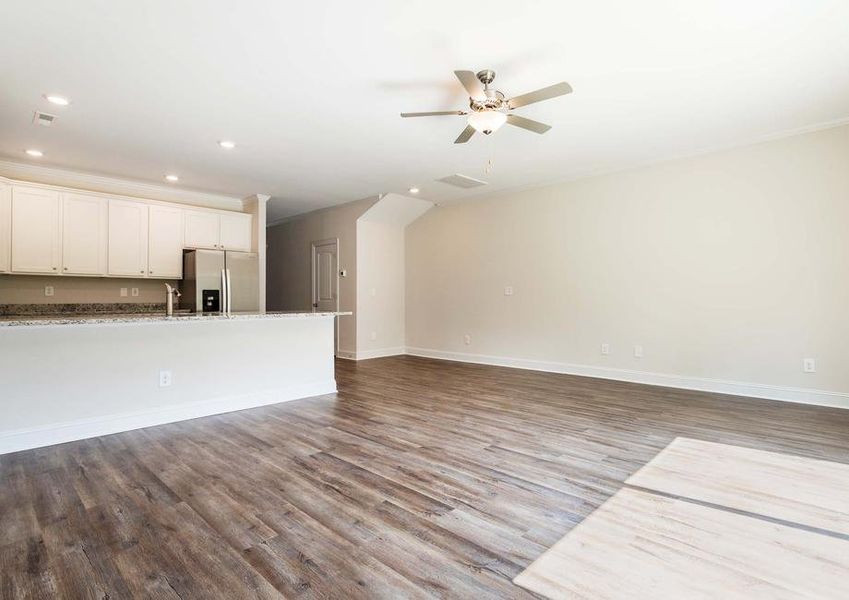 Living room and dining area located off the kitchen. Showcasing vinyl flooring and a ceiling fan.