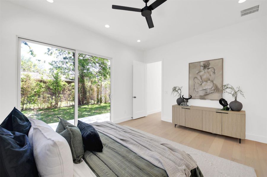 Primary bedroom with light wood-style flooring, recessed lighting, a ceiling fan, and access to exterior