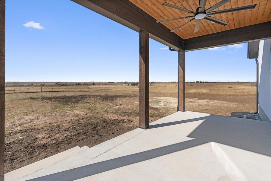 View of patio / terrace with a view of rural / pastoral area and ceiling fan