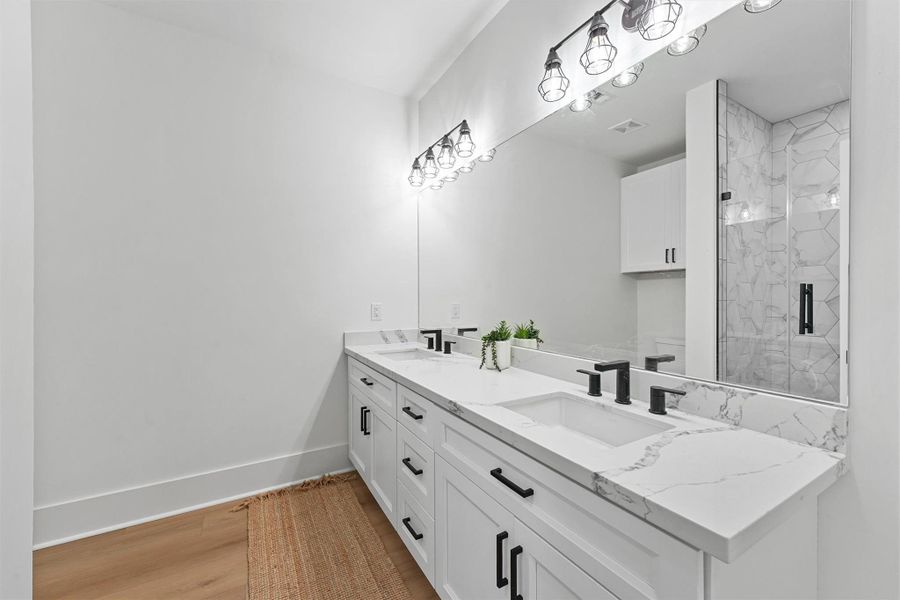 Stylish full bathroom with modern quartz countertops, under-mount sinks, and a blend of clean lines and soft lighting. Stylish full bathroom with modern quartz countertops, under-mount sinks, and a blend of clean lines and soft lighting.