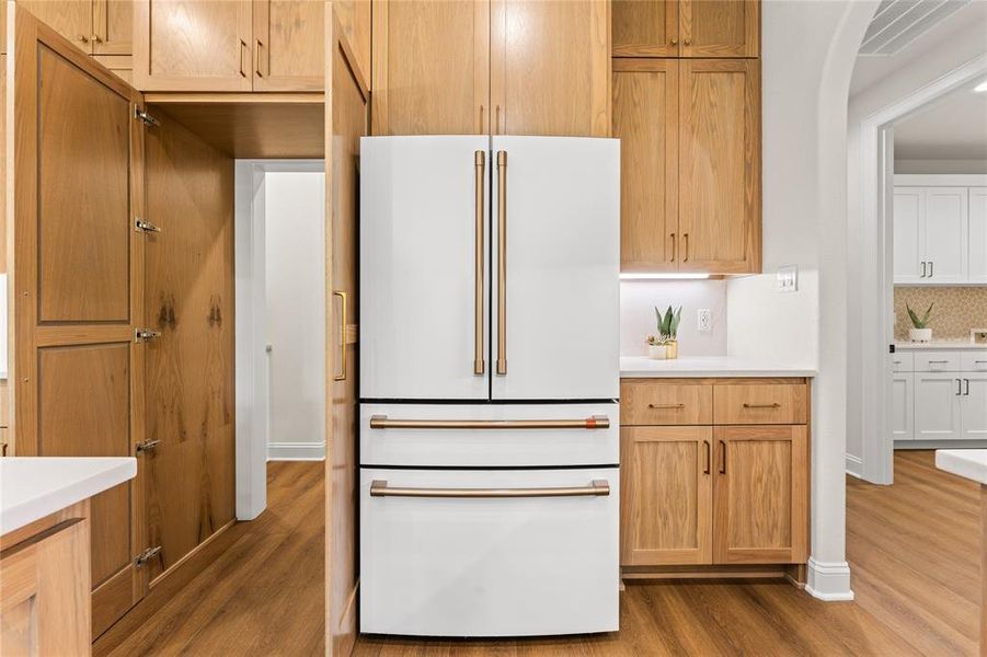 Kitchen featuring high end fridge, light wood-style flooring, and backsplash