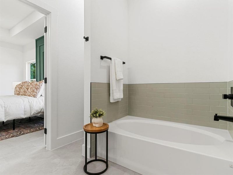 Full bathroom featuring a garden tub and connected bathroom