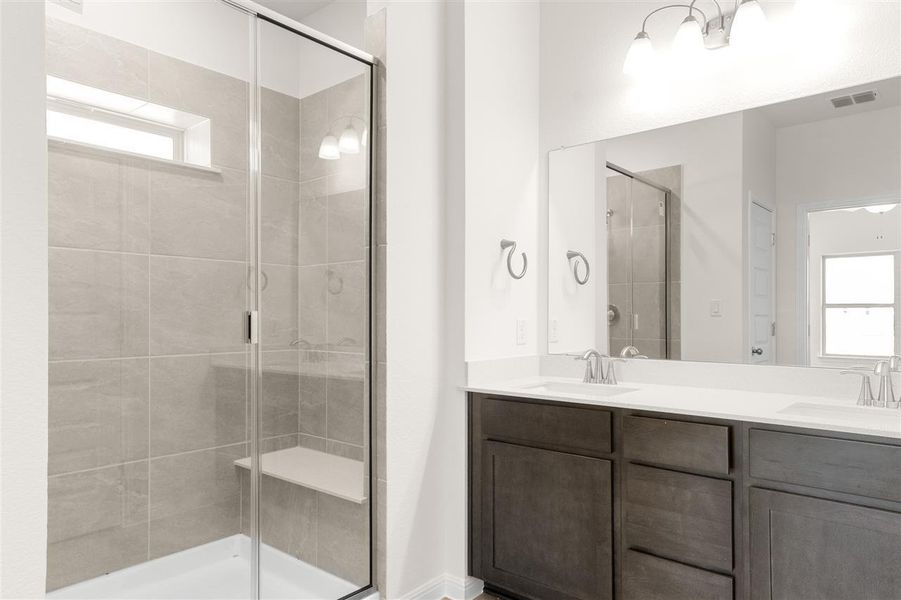 Full bath featuring a stall shower, plenty of natural light, and a sink