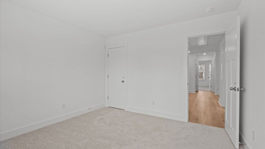 Tasteful bedroom with plush carpet, a walk-in closet, and large windows for abundant natural light located in Greenville, SC