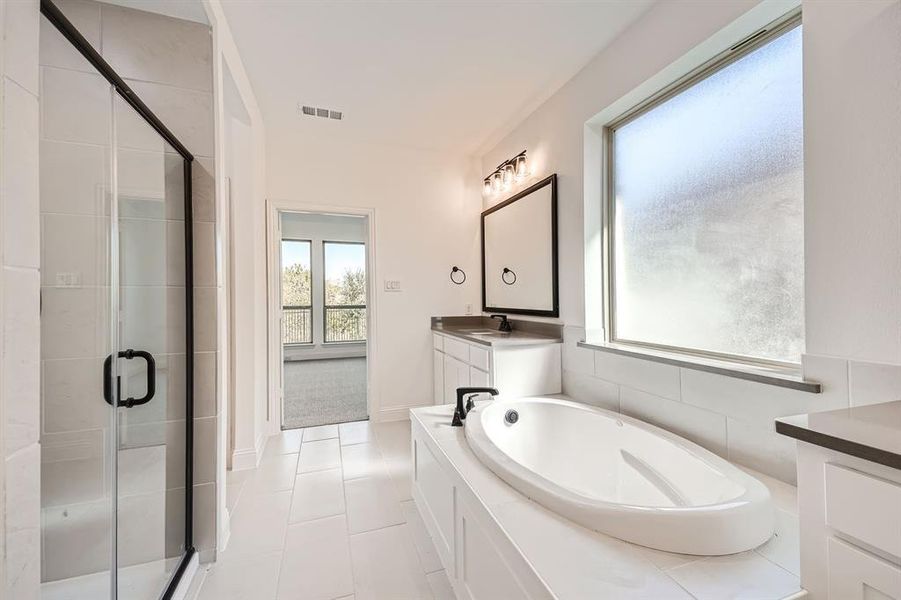 Bathroom with independent shower and bath, vanity, tile walls, and tile patterned floors