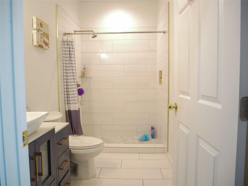 Full bath featuring vanity, a shower stall, and tile patterned flooring