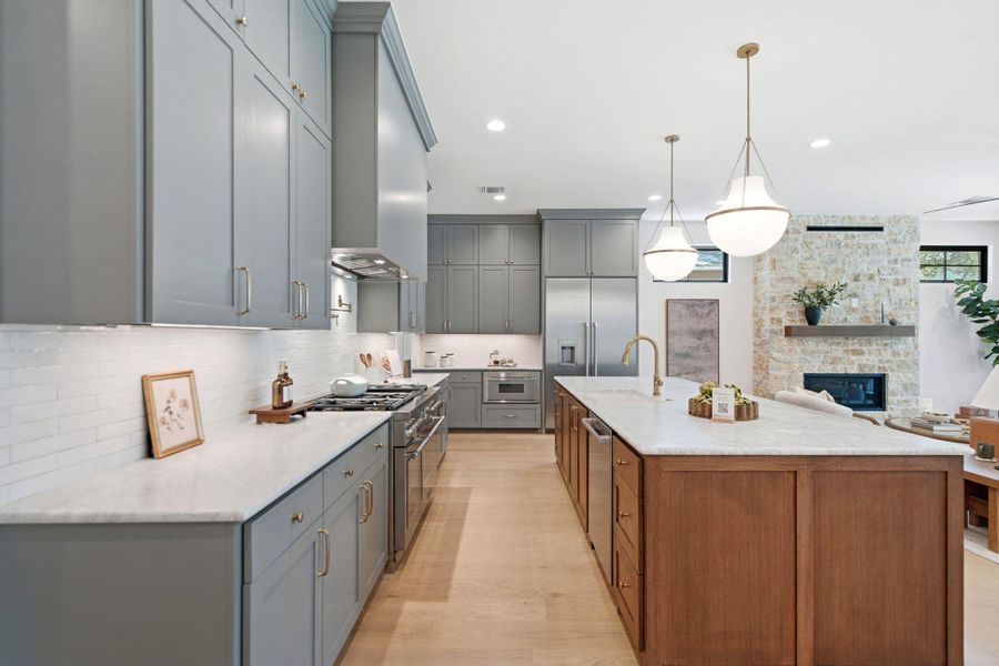 Tailored cabinetry and stone countertops anchor this gourmet workspace flowing into an airy living area.