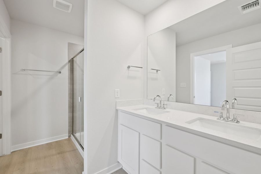 A bathroom with white cabinets.