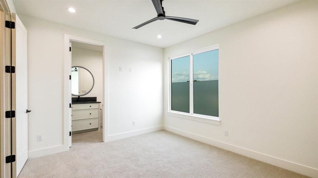 Unfurnished bedroom with light carpet and ceiling fan